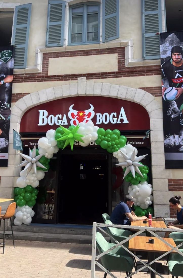 Arche de ballons verte et blanche à l'entrée d'un restaurant palois